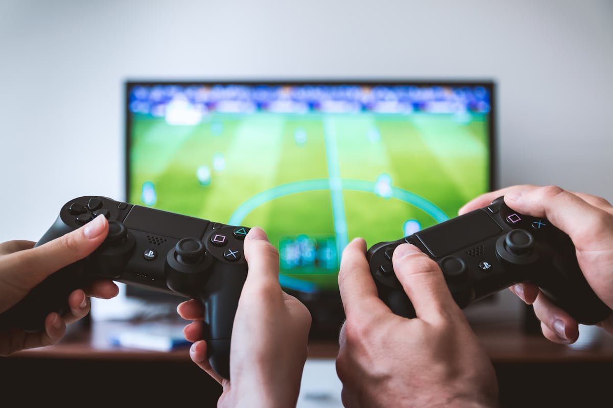 Friends playing console games on a sofa